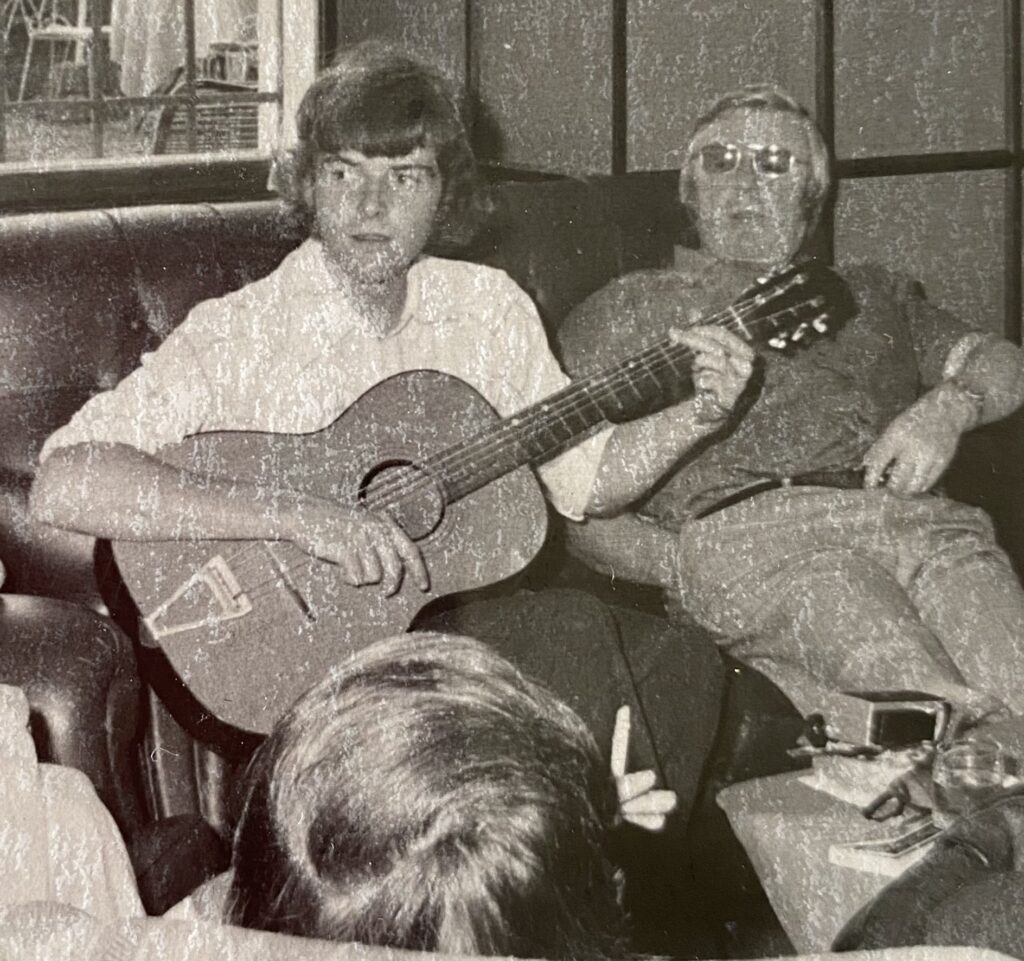 Black and white photograph of Paul playing a guitar in a hotel bar near Lake Maggiore, Italy, in September 1975 (aged 18).
